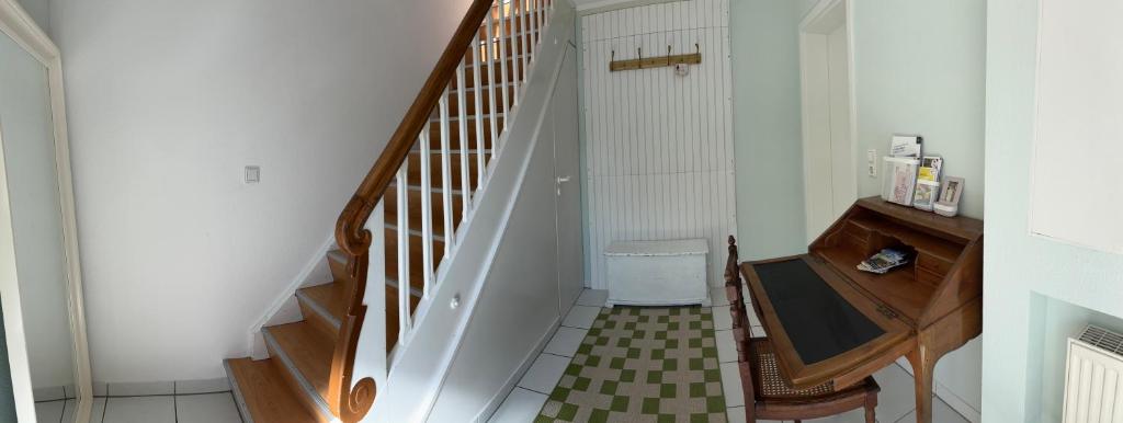 a hallway with a white staircase with a trash can at Heimelige Wohnung Bei der Stoffschmiede in Schutterwald