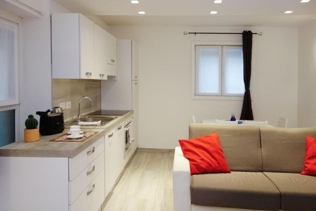 a living room with a couch and a kitchen at Ca di baragett in Mandello del Lario