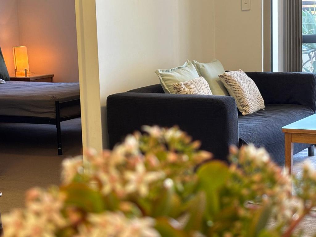 a living room with a blue couch with pillows at Courtyard apartment in Perth