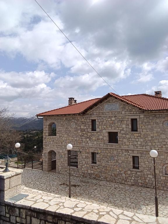 a large stone building with a red roof at Petra & Elato Art Hotel in Valtessiniko