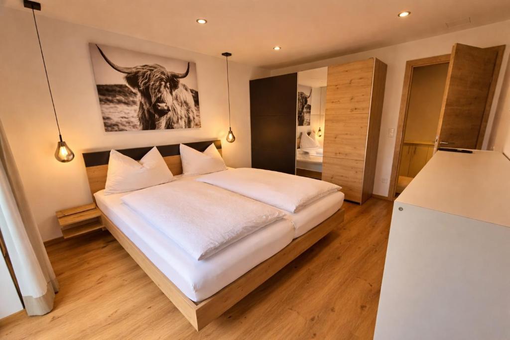 a bedroom with a bed with a bull picture on the wall at Tante Maridi in Forstau