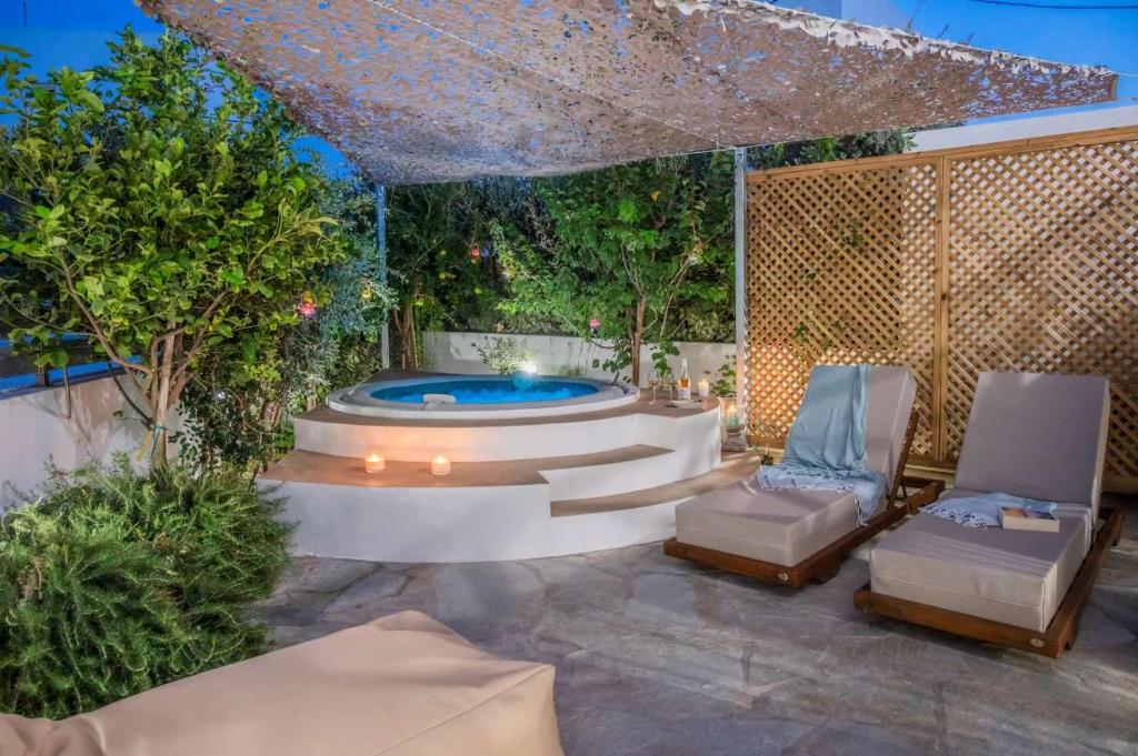 eine Terrasse mit Whirlpool und zwei Stühlen in der Unterkunft Osura in Vári