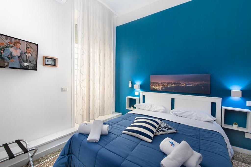 a blue bedroom with a large bed with blue walls at Mellos B&B in Naples