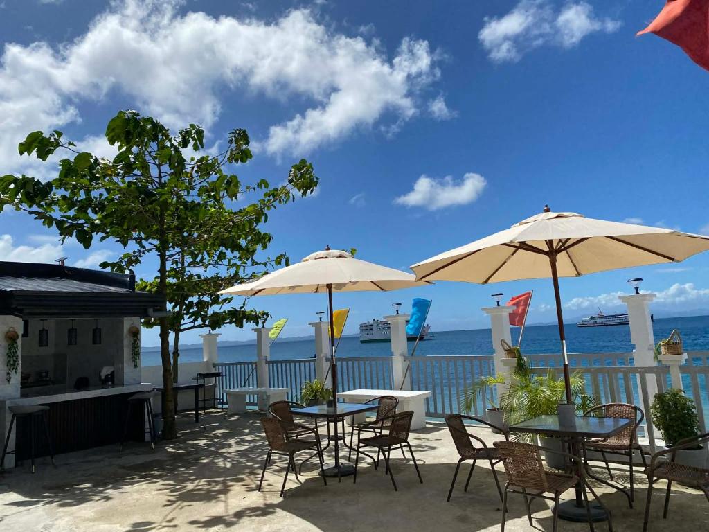a patio with tables and chairs and umbrellas at Beachfront Sunset Getaway in Allen