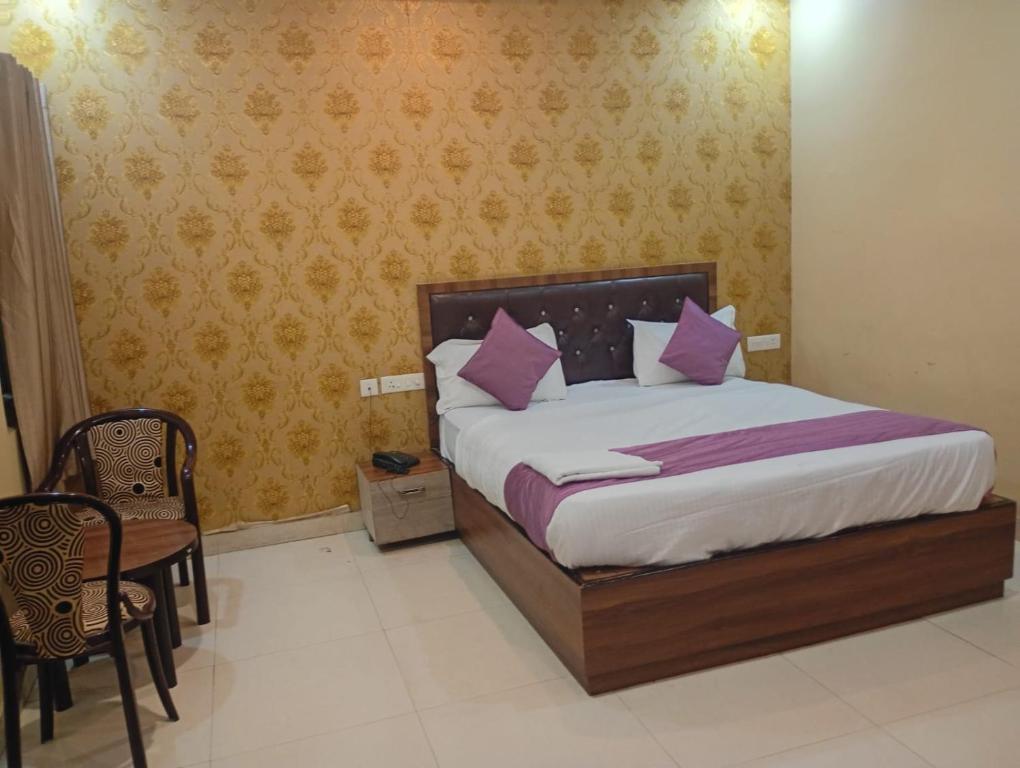 a bedroom with a bed with pink pillows on it at Hotel Grand Inn in Lucknow