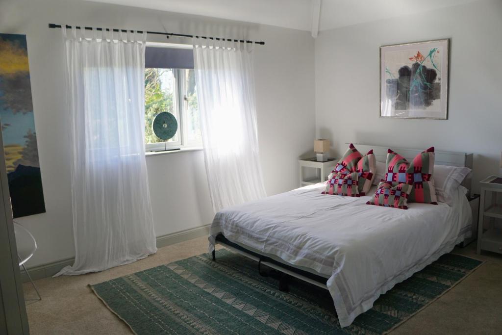 a bedroom with a bed with red pillows and a window at Knowle Grange Guest House in Frant