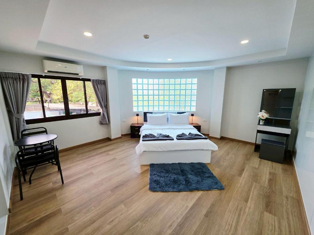 a large room with two beds and a desk at M-Well House in Sathani Ban Hua Mak