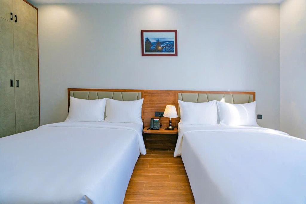 two beds sitting next to each other in a room at Thời đại Hotel in Thanh Hóa