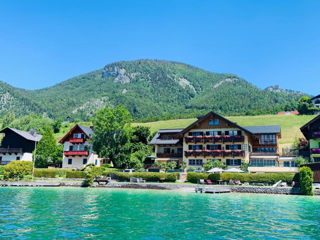 a group of houses on the shore of a lake at Hotel Garni Buchinger in St. Wolfgang