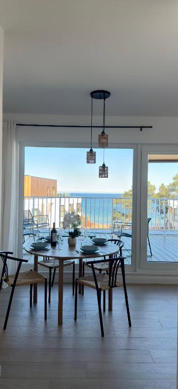 a dining room with a table and chairs and a large window at Let's Sea Positive Vibe apartment in Gąski