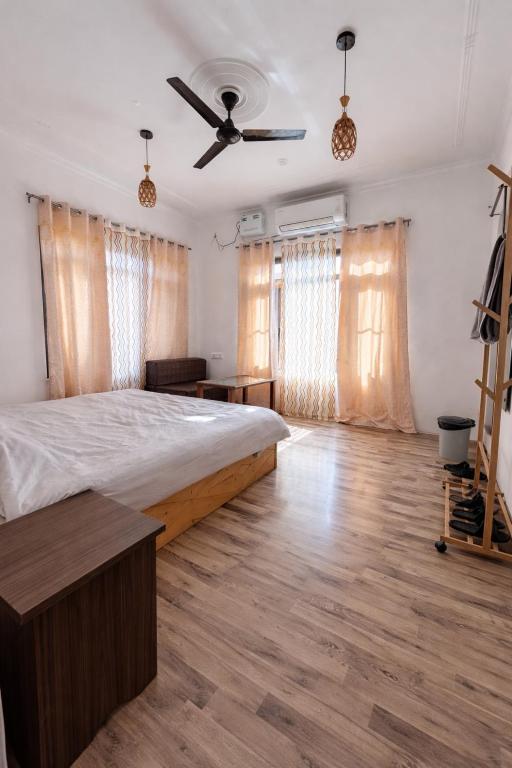 ein Schlafzimmer mit Bett und Deckenventilator in der Unterkunft John's Homestay Srinagar - Stay Ride Hike in Srinagar