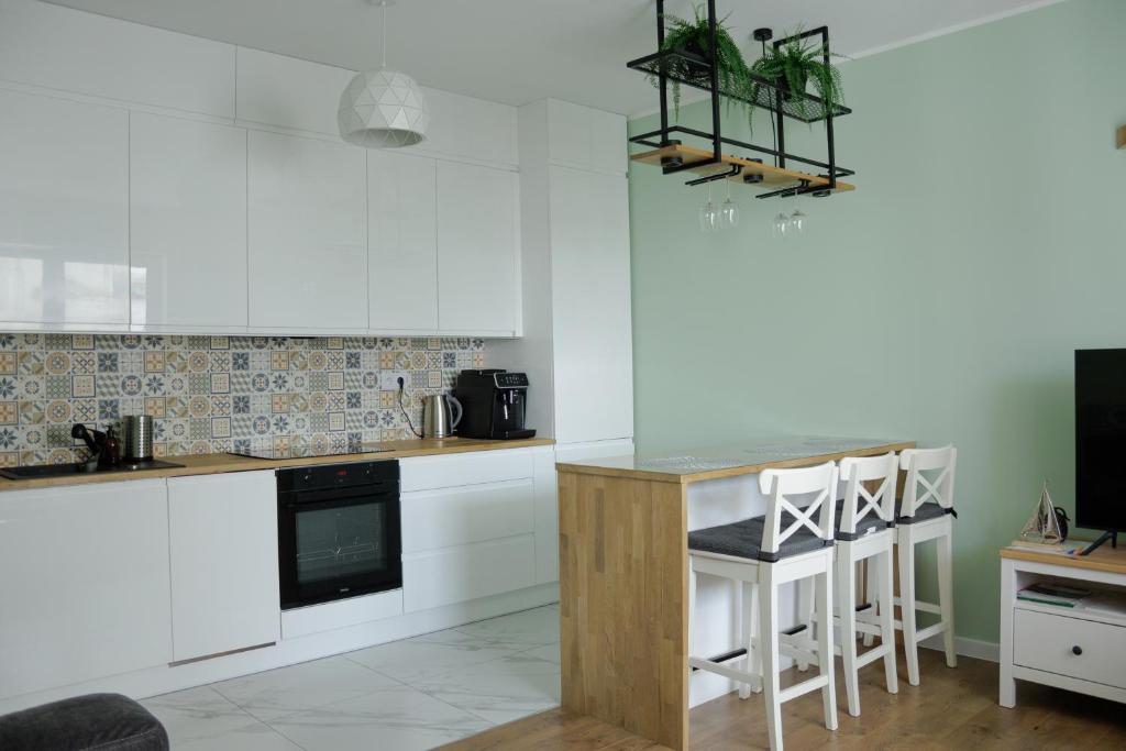 a kitchen with white cabinets and a counter top at APARTAMENT PRZYSTAŃ in Giżycko
