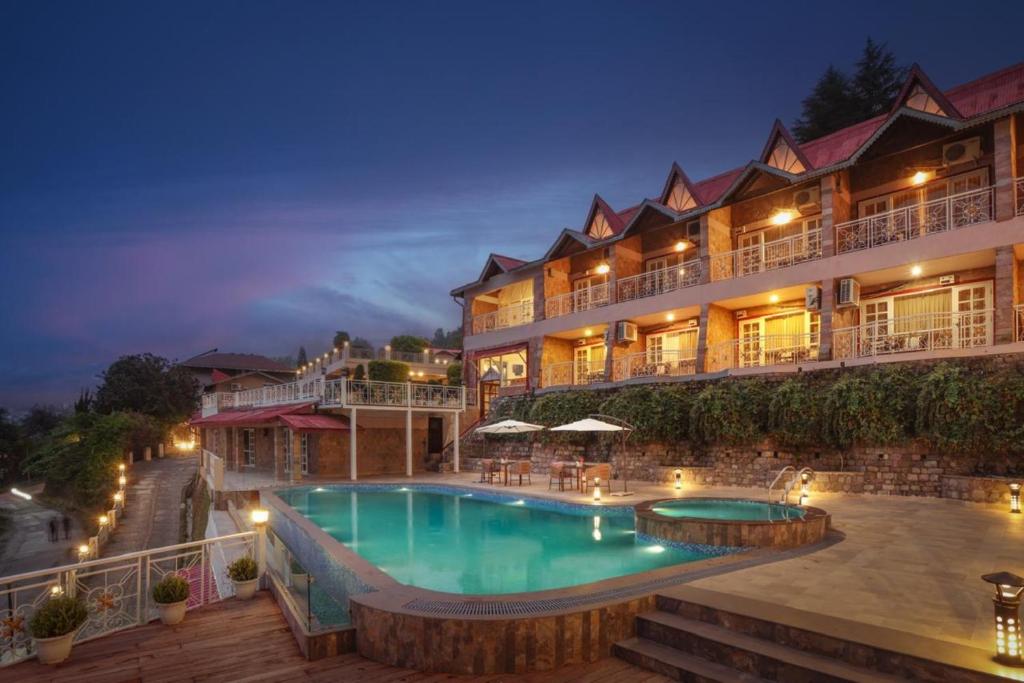a hotel with a swimming pool at night at Neelesh Inn - Luxury Lake View Resort with Swimming Pool on Bhimtal Lake in Bhīm Tāl