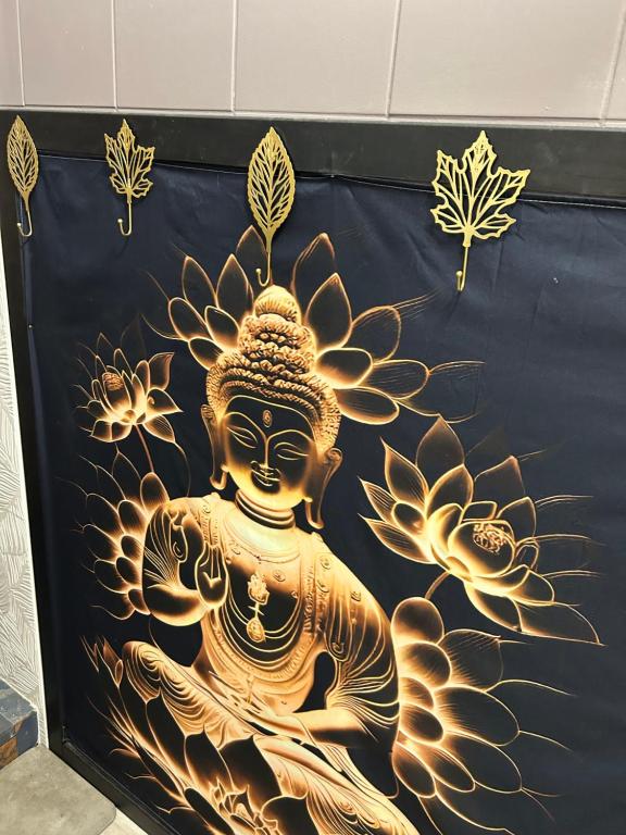 a wall with a gold painting of a buddha at LE MERYCE appt in Saint-Denis