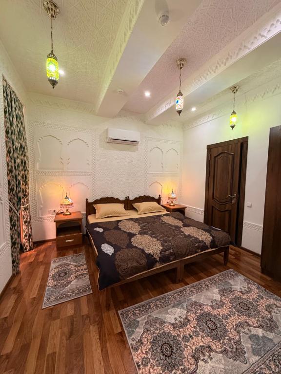 a bedroom with a bed and two night stands and two lamps at GUZAL Boutique Hotel in Bukhara