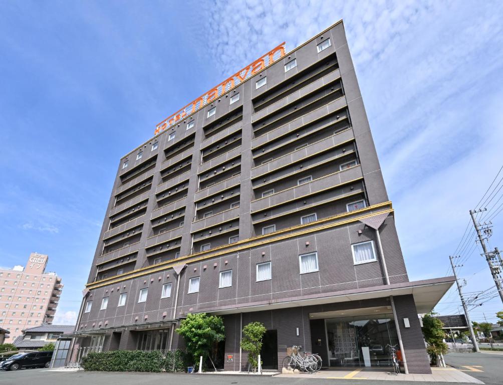 a tall building with an orange sign on it at Hotel nanvan浜名湖 in Kosai