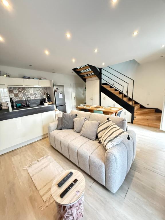 a living room with a couch and a kitchen at Charmant appartement à Roanne in Roanne