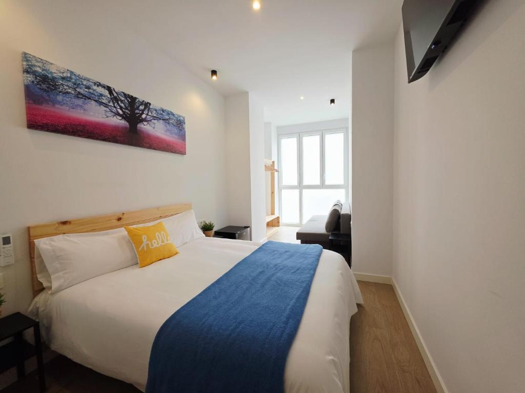 a bedroom with a bed and a painting on the wall at Bilbao ROOMS & KITCHEN Zabalburu in Bilbao