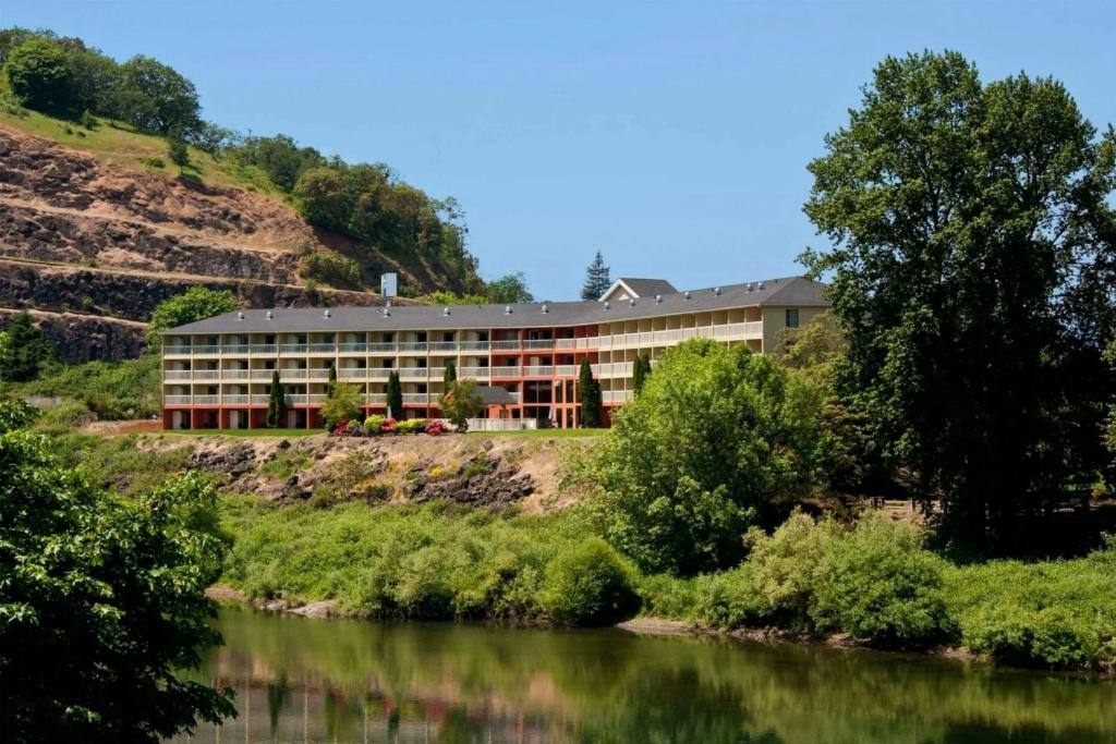 a building on the side of a river at The Lodge at Roseburg in Roseburg