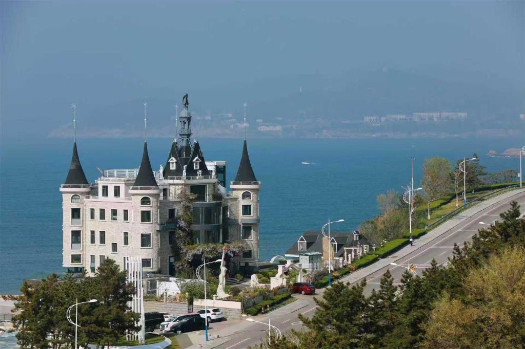 a large white building on the side of a road at Bay Four Seasons Castle Hotel in Weihai