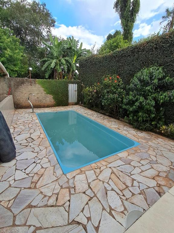 a swimming pool in a yard with a stone patio at Recanto Campo Belo in Monte Sião