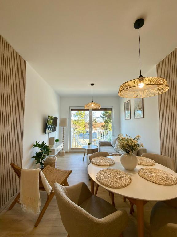 a living room with a table and chairs at Apartament Boho Let's Sea Gąski in Gąski