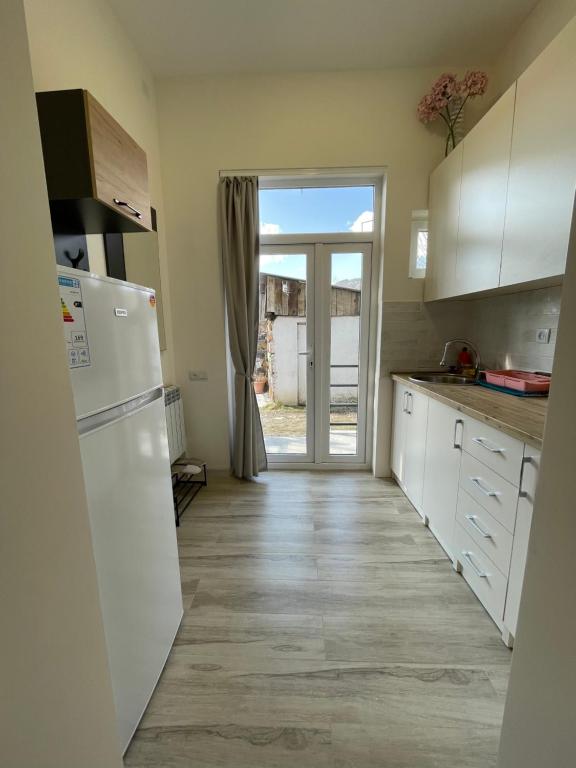 a kitchen with a refrigerator and a door to a yard at Sweet Home in Dilijan