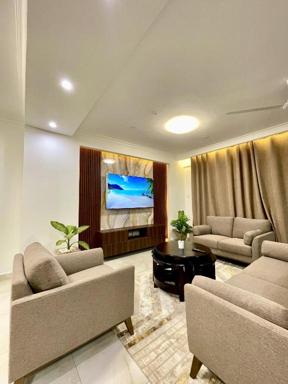 a living room with two couches and a tv at Tulivu Beach Stays in Jeuri