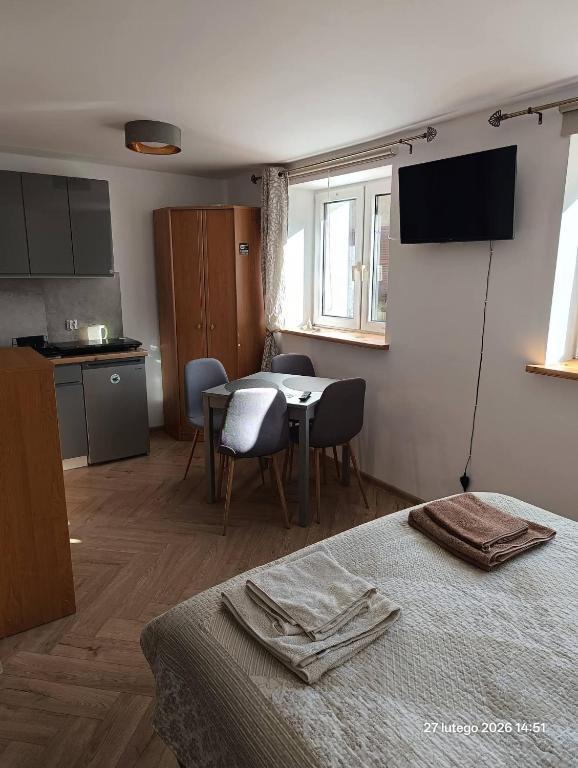 a room with a bed and a table and a kitchen at Pokoje gościnne Cyraneczka in Lądek-Zdrój