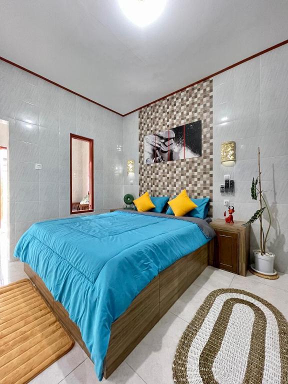 a bedroom with a large bed with blue sheets and yellow pillows at 1 BR Private Studio Apartment with Kitchen in Kerobokan