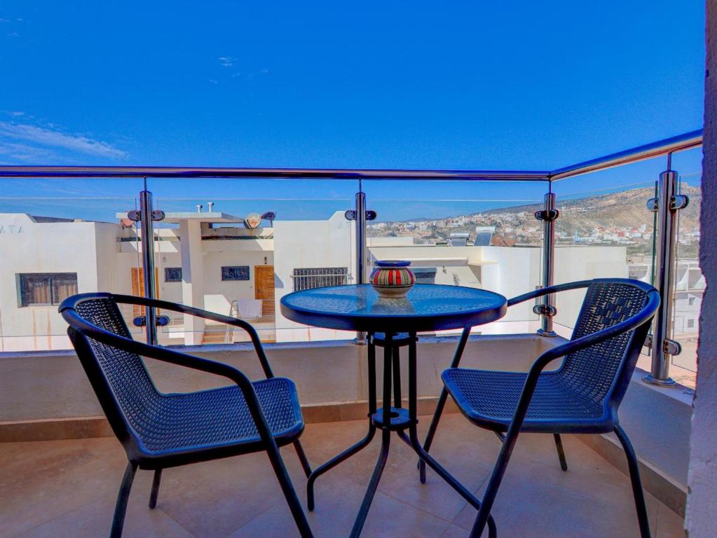 a table and chairs on a balcony with a view at Beach Apartment with Pool Banana Beach Surf Spot in Aourir