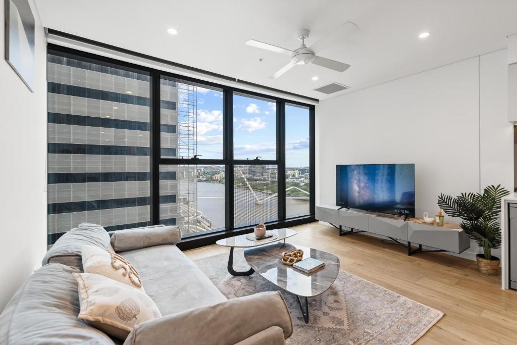 a living room with a couch and a large window at CBD Luxury River View & Fireworks 1Bed Apt The One in Brisbane