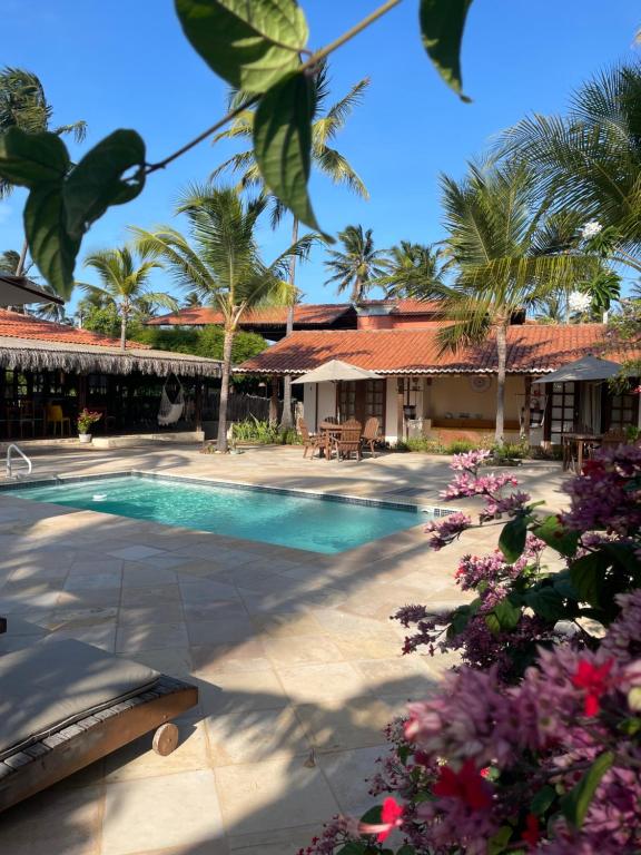 a resort with a swimming pool and palm trees at Pousada Vila Icaraí in Icaraí
