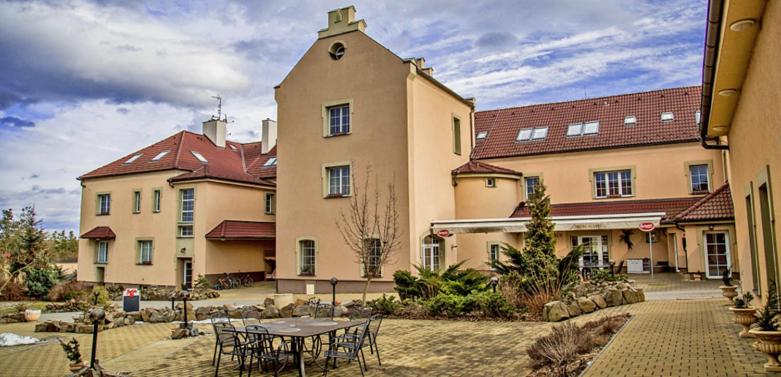 a large building with a table in front of it at Hotel Allvet in Drnovice