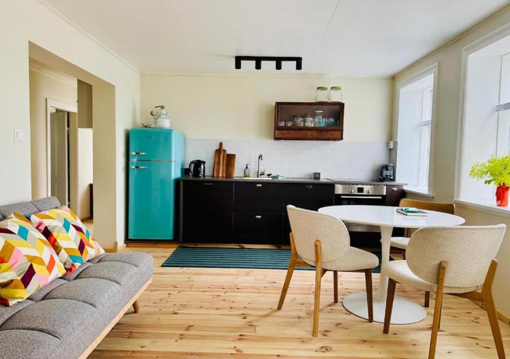 a living room with a couch and a table and a kitchen at Downtown Boutique Apartment in Akureyri