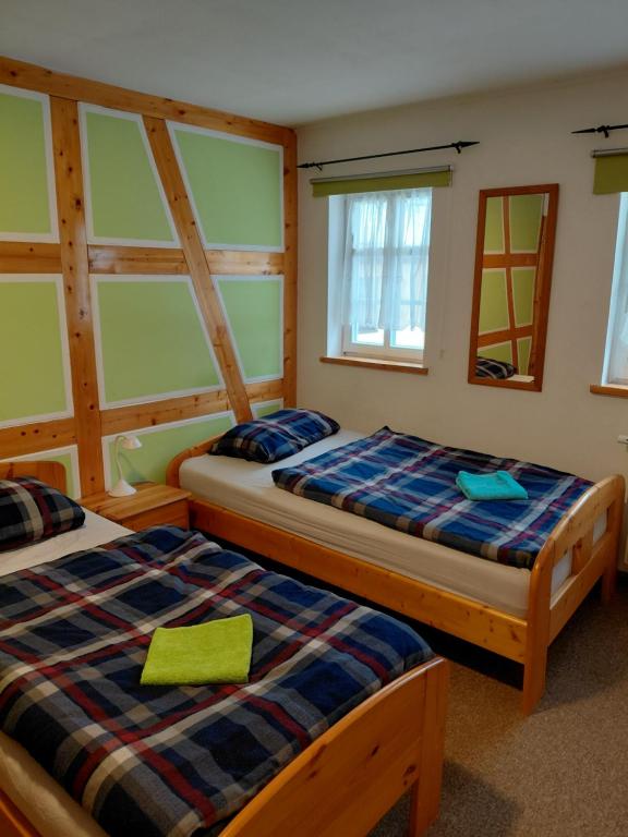 two beds sitting in a room with windows at Ferienwohnung Leon in Heldburg