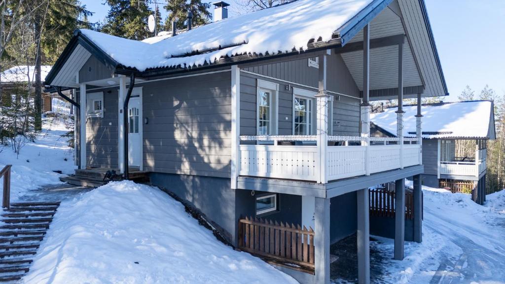 a small house with snow on the porch at Villa Magnolia 1 Himos in Jämsä