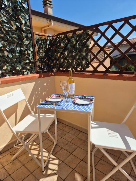 a small table with two chairs and a bottle of wine at Da Luca in Càbras