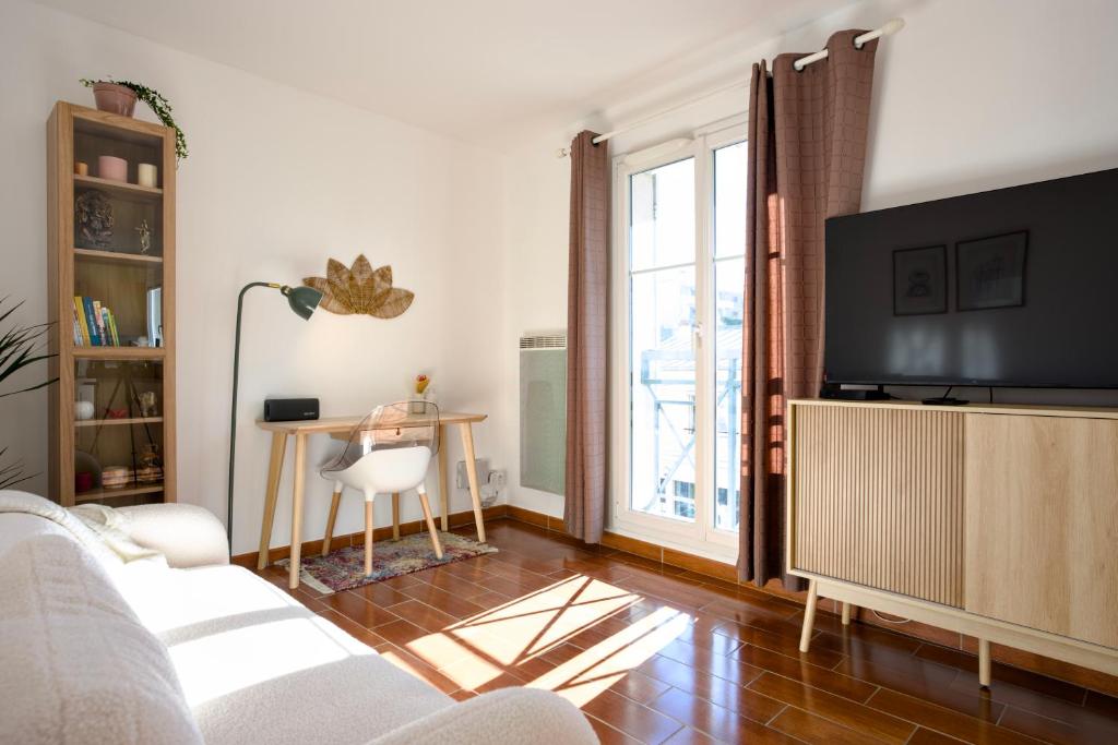 a living room with a couch and a table at Chez Leela in Poissy