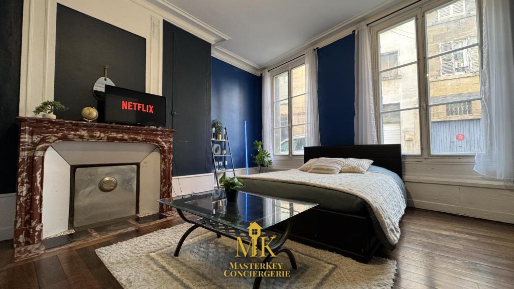 a bedroom with a bed and a fireplace at Le Bleuet Boulevard de la Rochelle, centre-ville in Bar-le-Duc