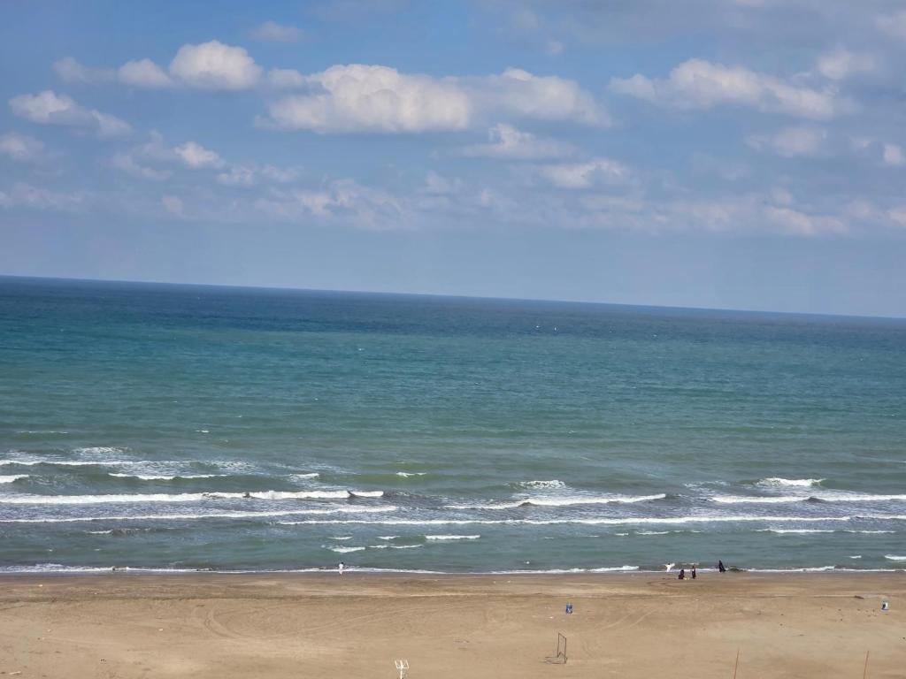 a group of people on a beach near the ocean at Muscat Beach Hostel in Muscat
