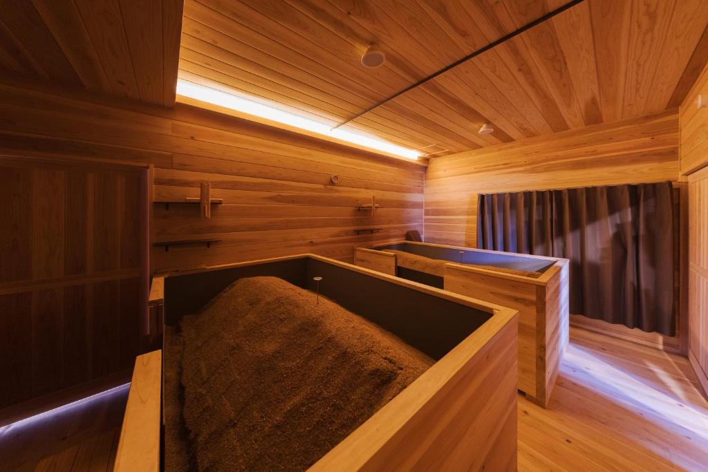 a wooden sauna with a large tub in a room at 杜の酵素808 in Takaharu