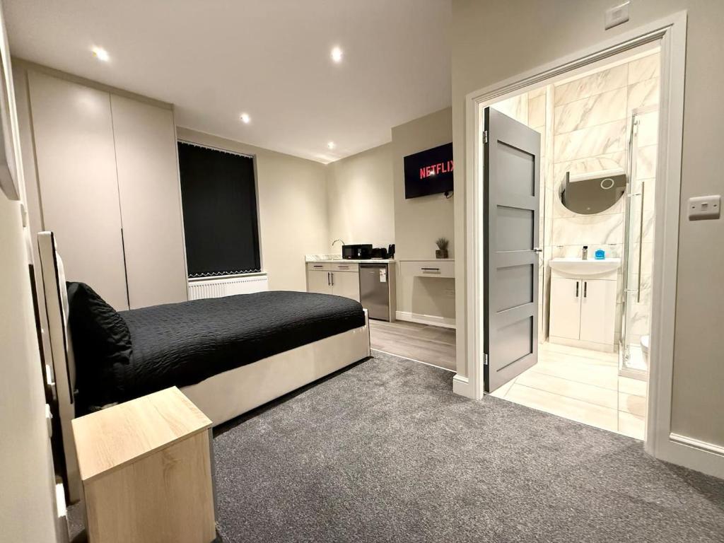 a bedroom with a bed and a bathroom with a sink at Aire House, Keighley in Keighley