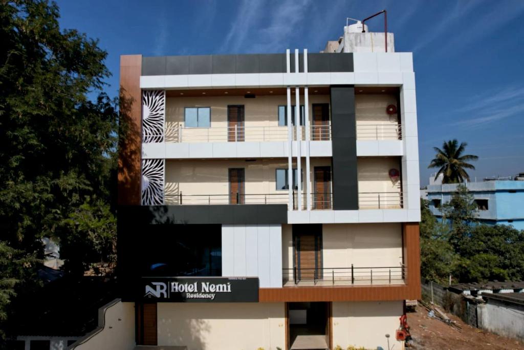 a white building with a sign in front of it at hotel nemi residency jagdalpur in Jagdalpur