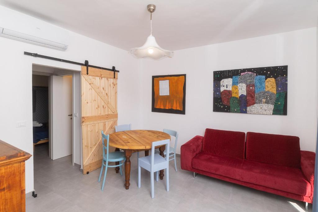a living room with a red couch and a table at Casa Brezza Marina in Punta Marina