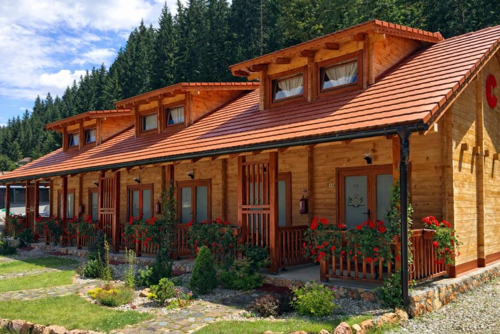 a wooden house with a wooden roof at Lacu Roșu Escape Lodge in Lacu Rosu