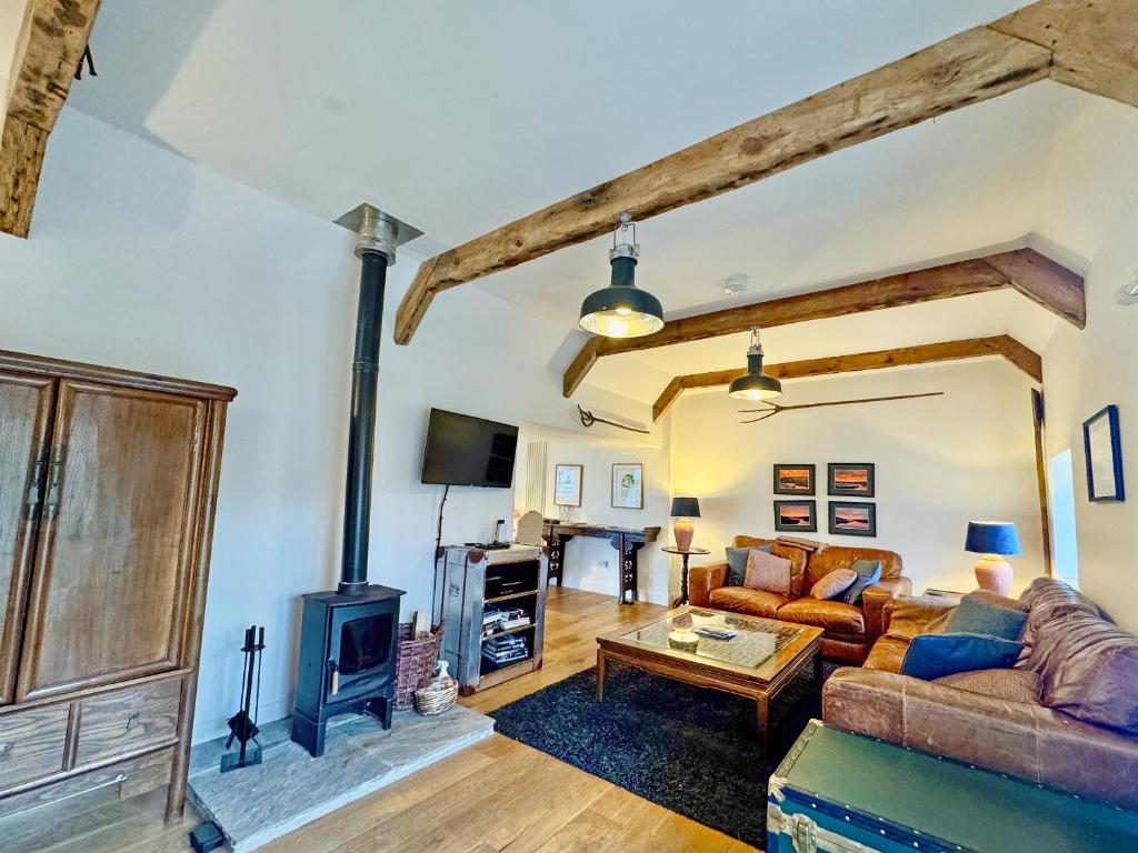 a living room with a couch and a wood stove at The Byre in Rispond