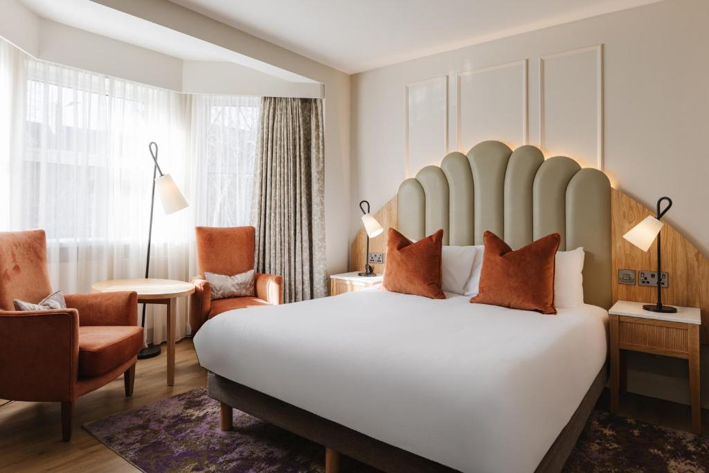 a hotel room with a large bed and a chair at The Malone Hotel in Belfast