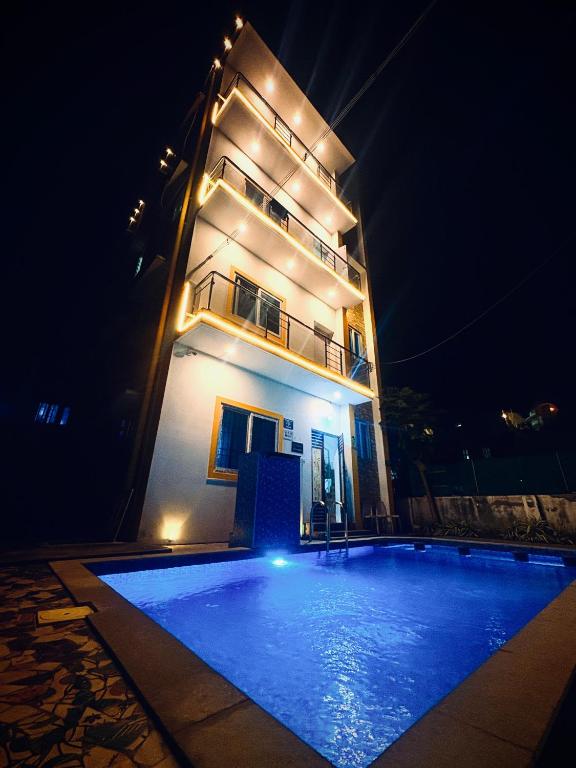 a building with a swimming pool in front of it at night at Dream stay villaa in Pondicherry