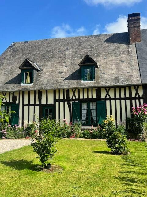 a black and white house with two windows at La Gruchette in Gruchet-Saint-Siméon
